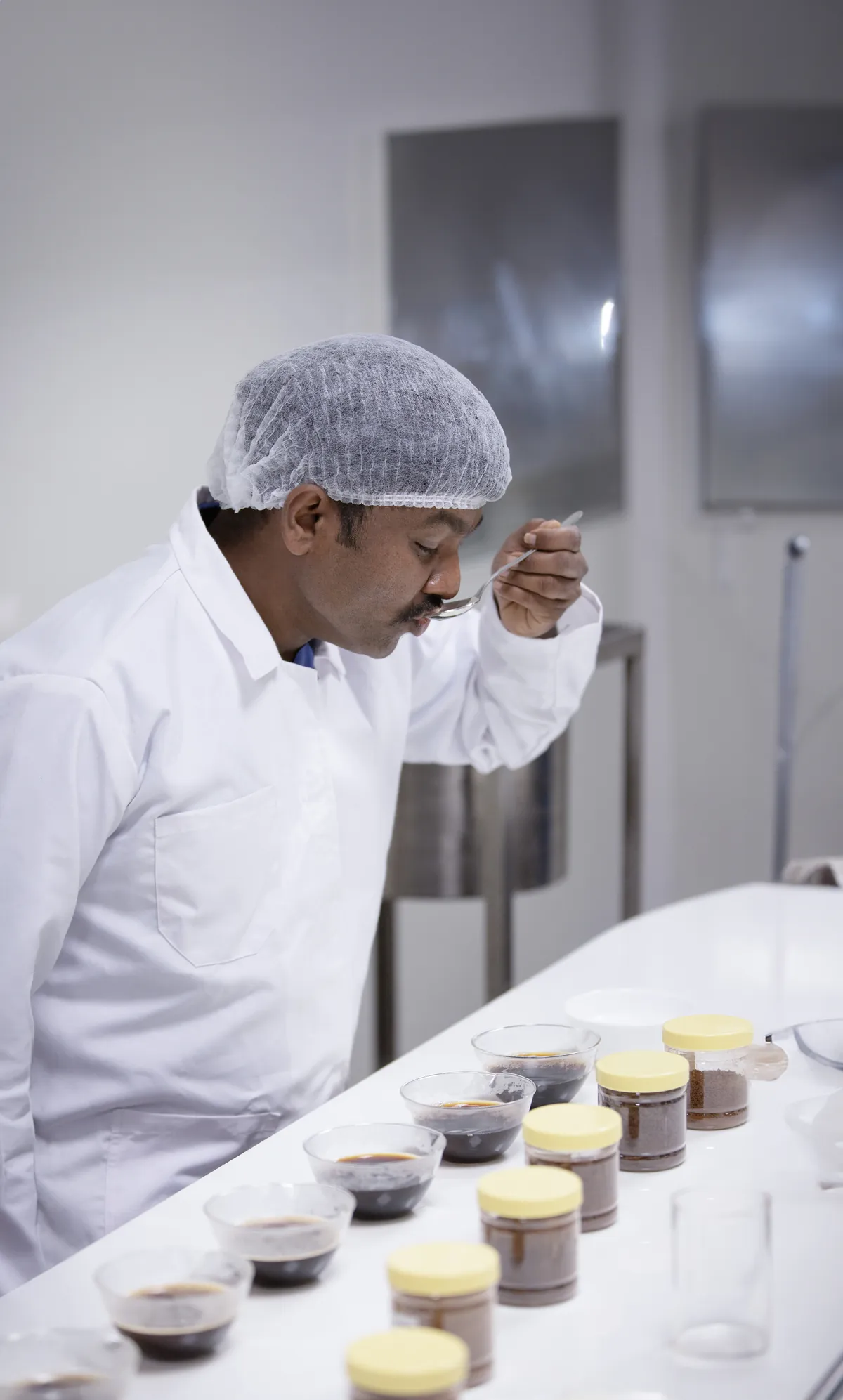 QC specialist aroma testing coffee samples in lab